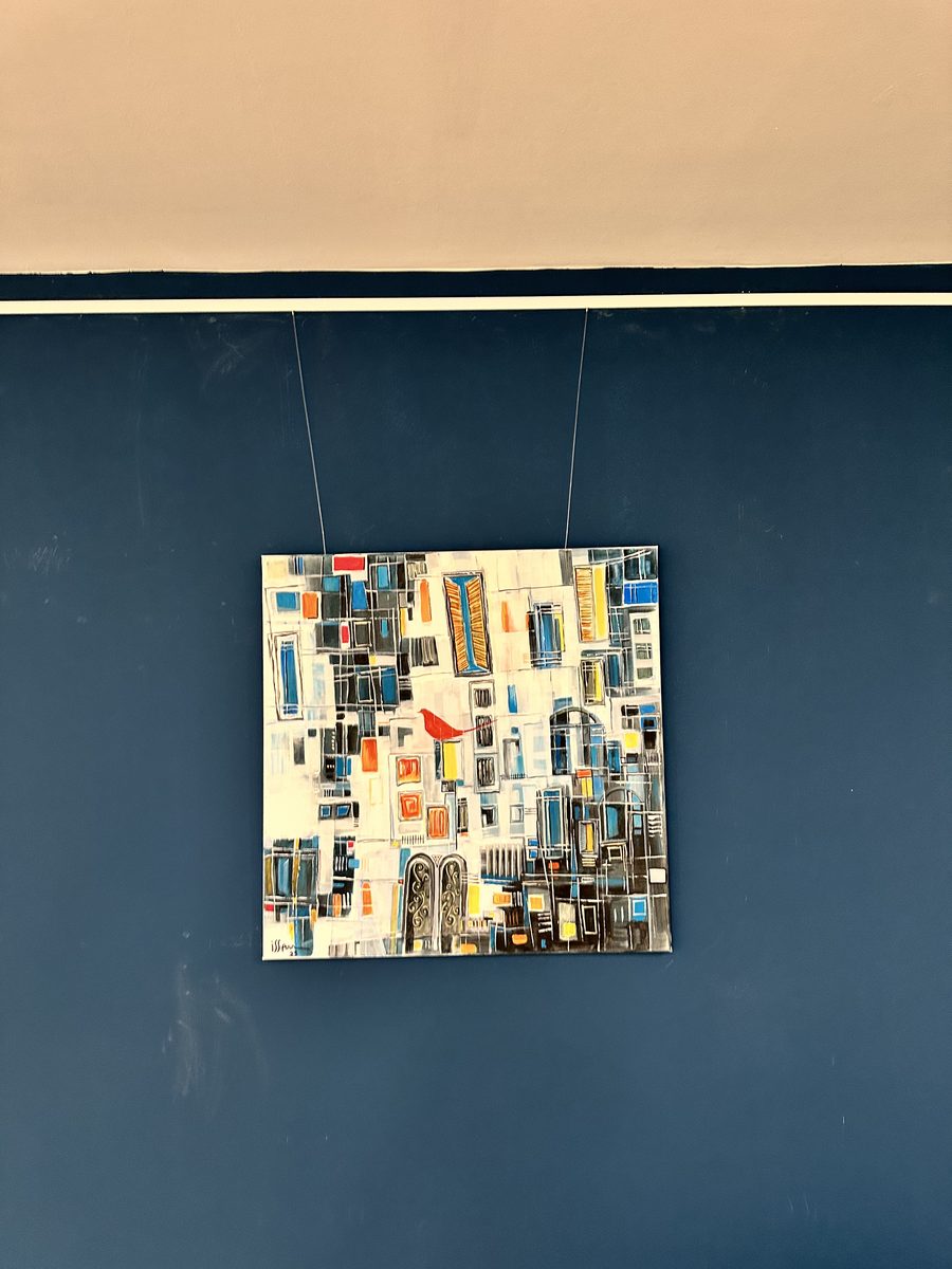 Quadratisches Stadtbild vor tiefblauer Wand